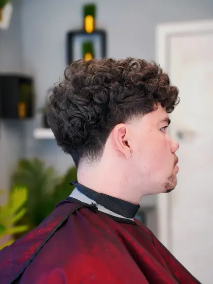 A curly top with a low taper, cut by Leandro Herrera