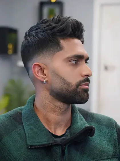 A high skin fade with a shaped full beard, in profile, cut by Leandro Herrera