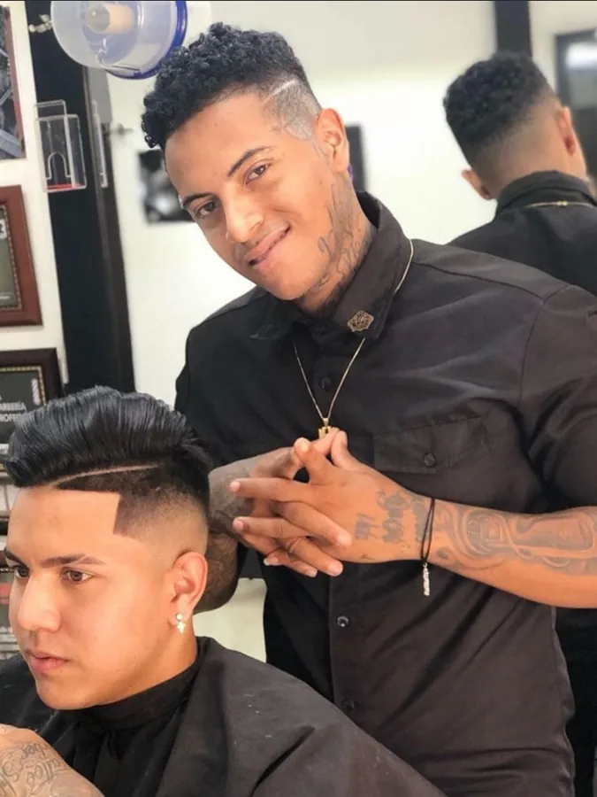 Leandro behind the chair, grinning at the pomp he has just finished.