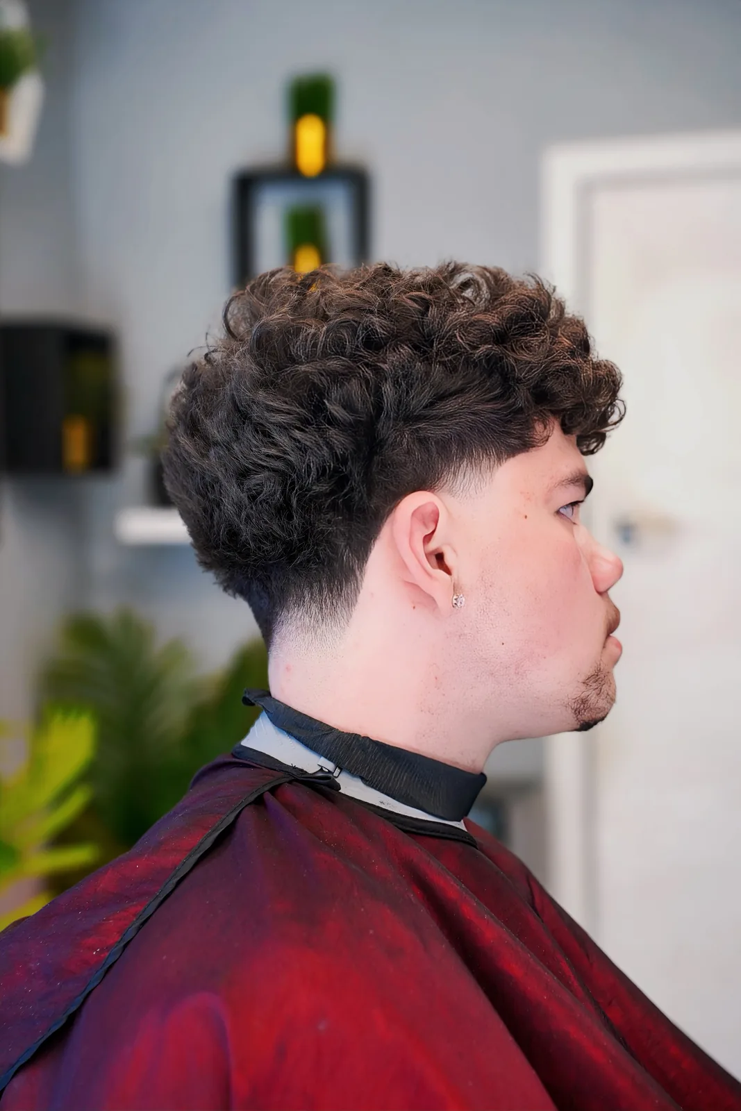A curly top with a low taper, cut by Leandro Herrera
