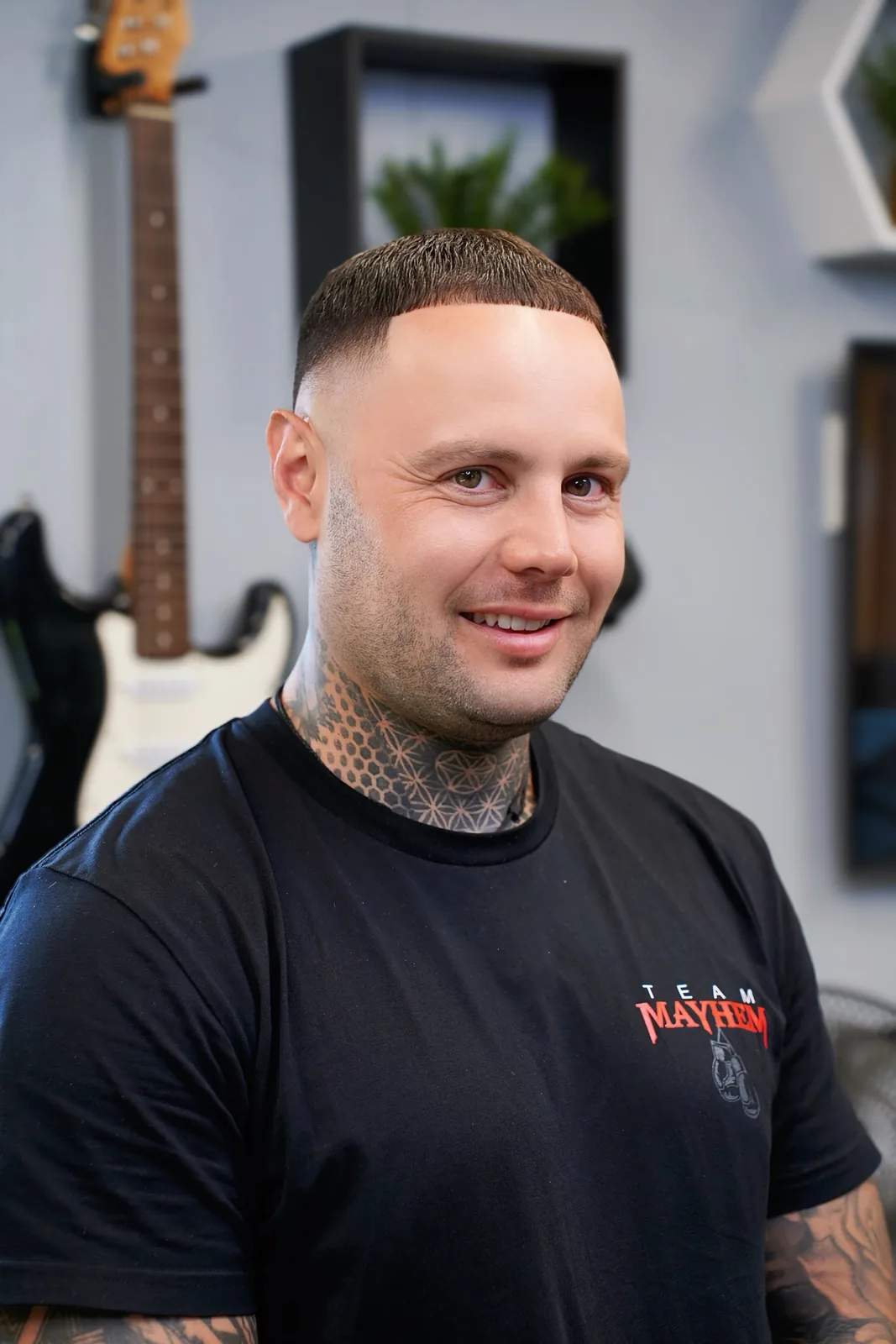 A client smiling in the chair after a skin-fade crop.