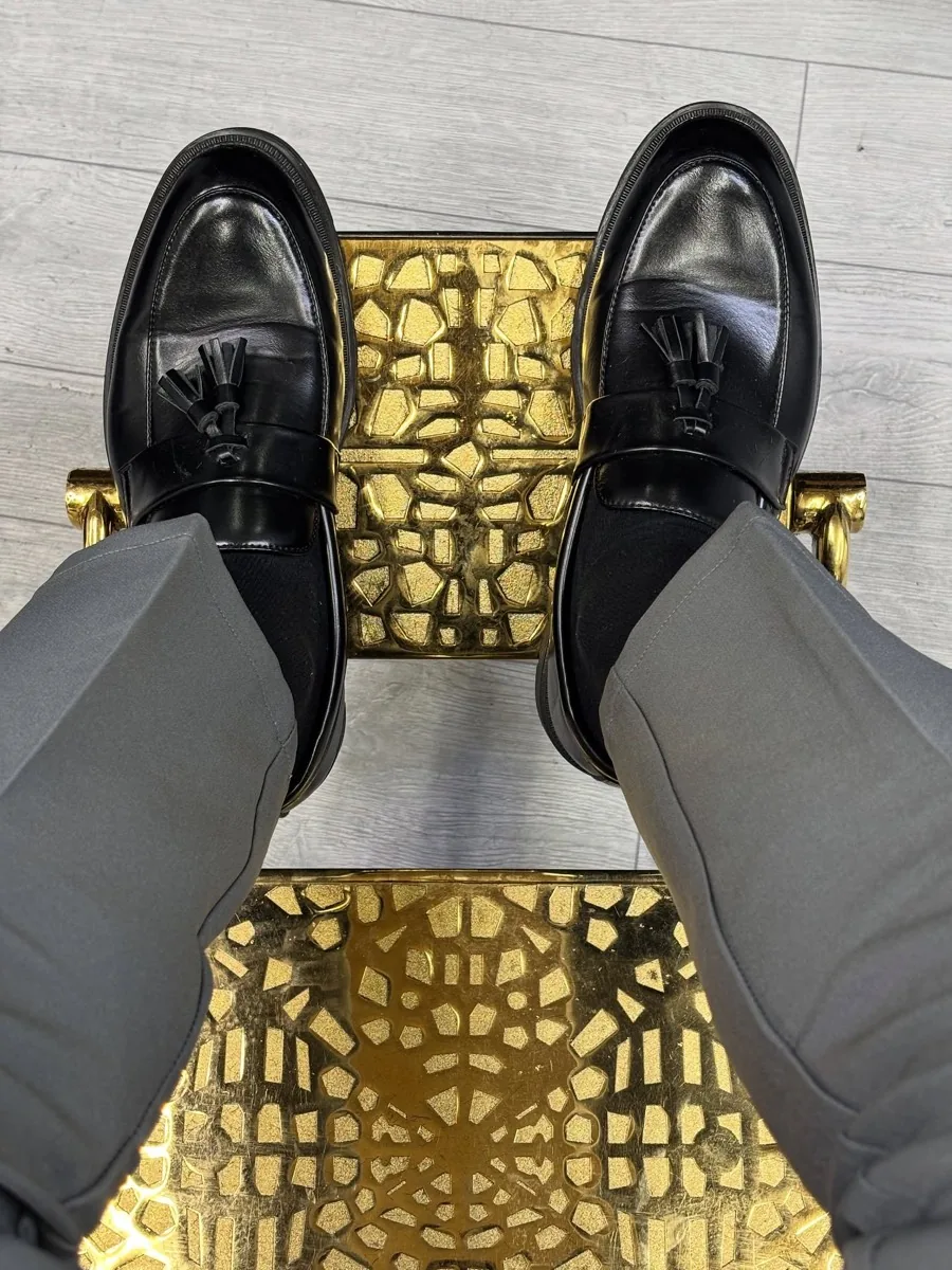 A client's shoes resting on the chair's gold footplate.